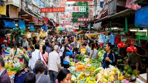 a crowd of people at a fruit stand